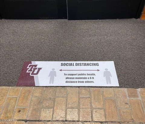 Social Distancing Sign shown on floor in the library